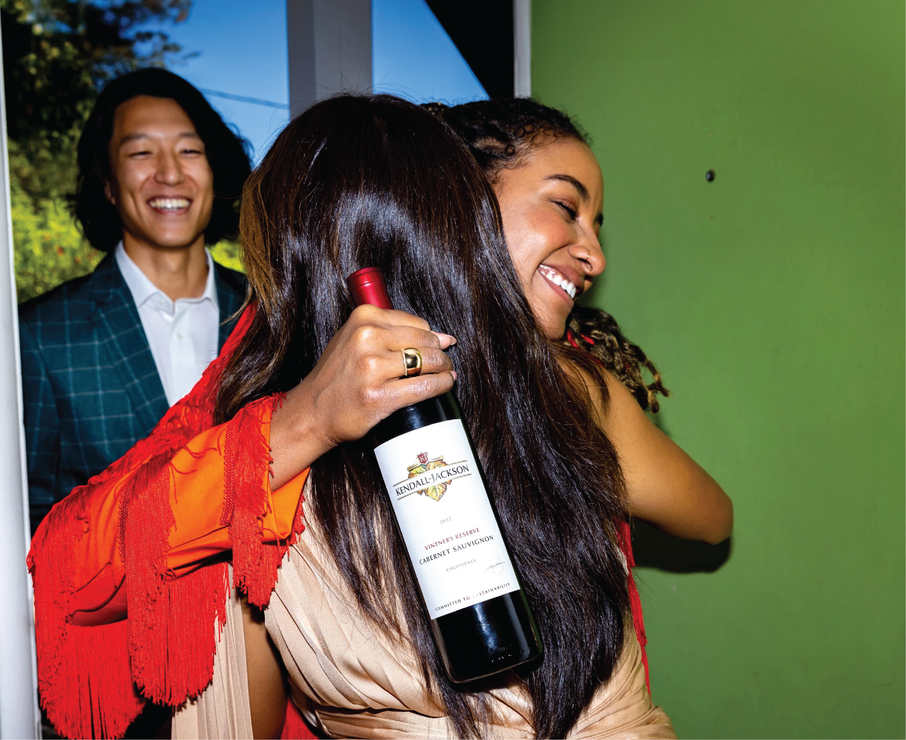 Friends enjoying a hug with a Kendall-Jackson wine bottle in their hand