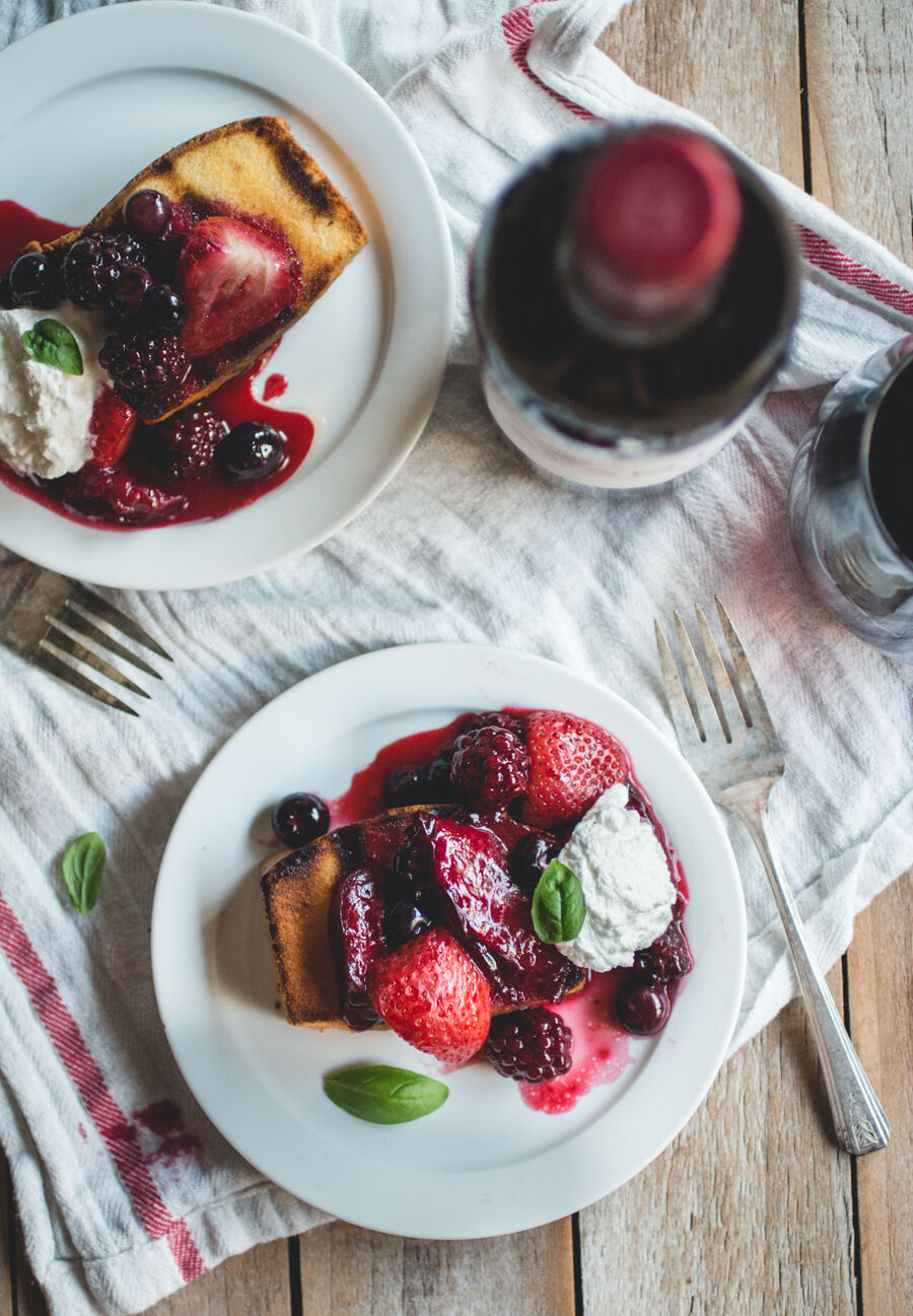 Overhead shot of grilled fruit with pound cake and wine