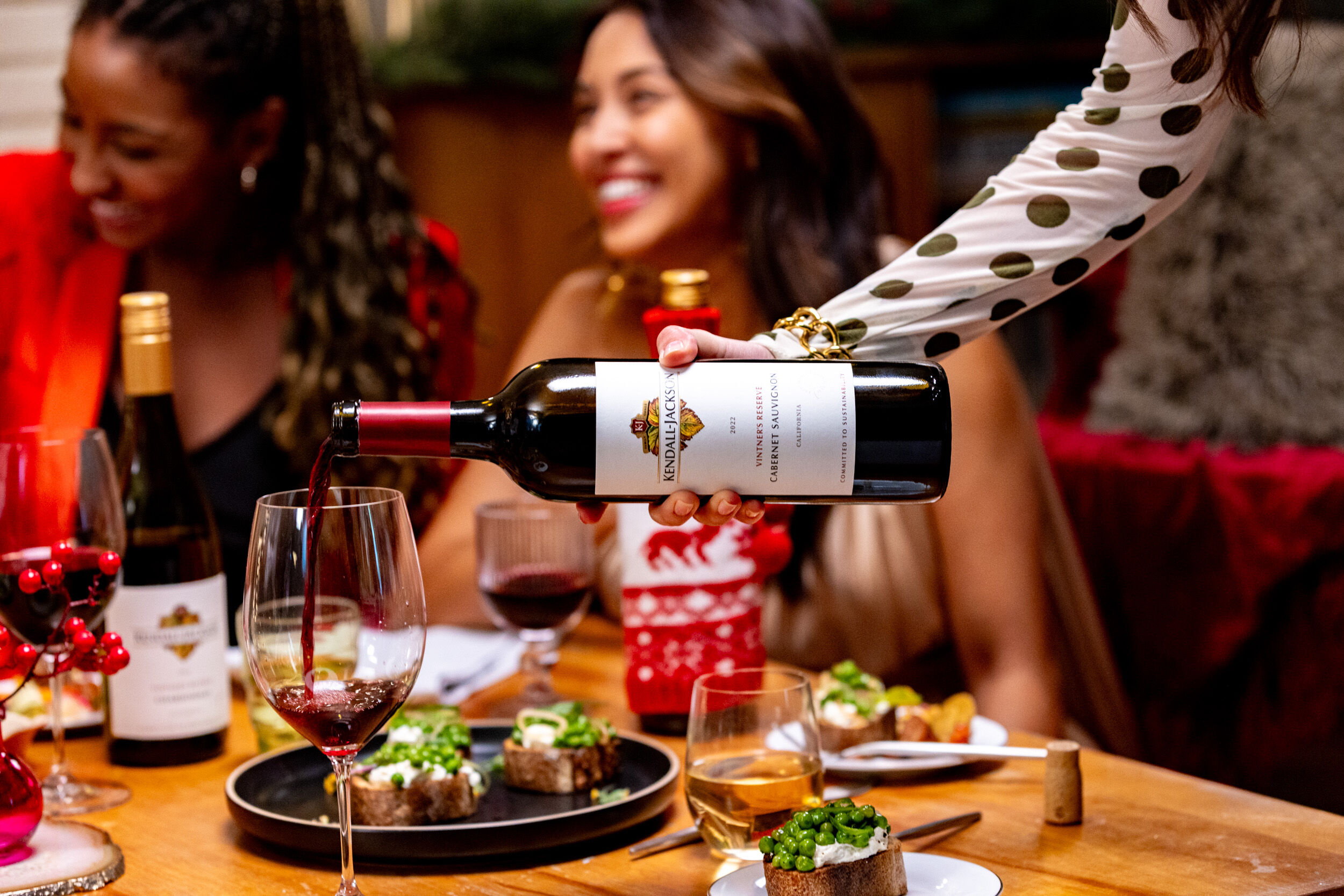 Friends at a table enjoying a Holiday meal and Kendall-Jackson Wine