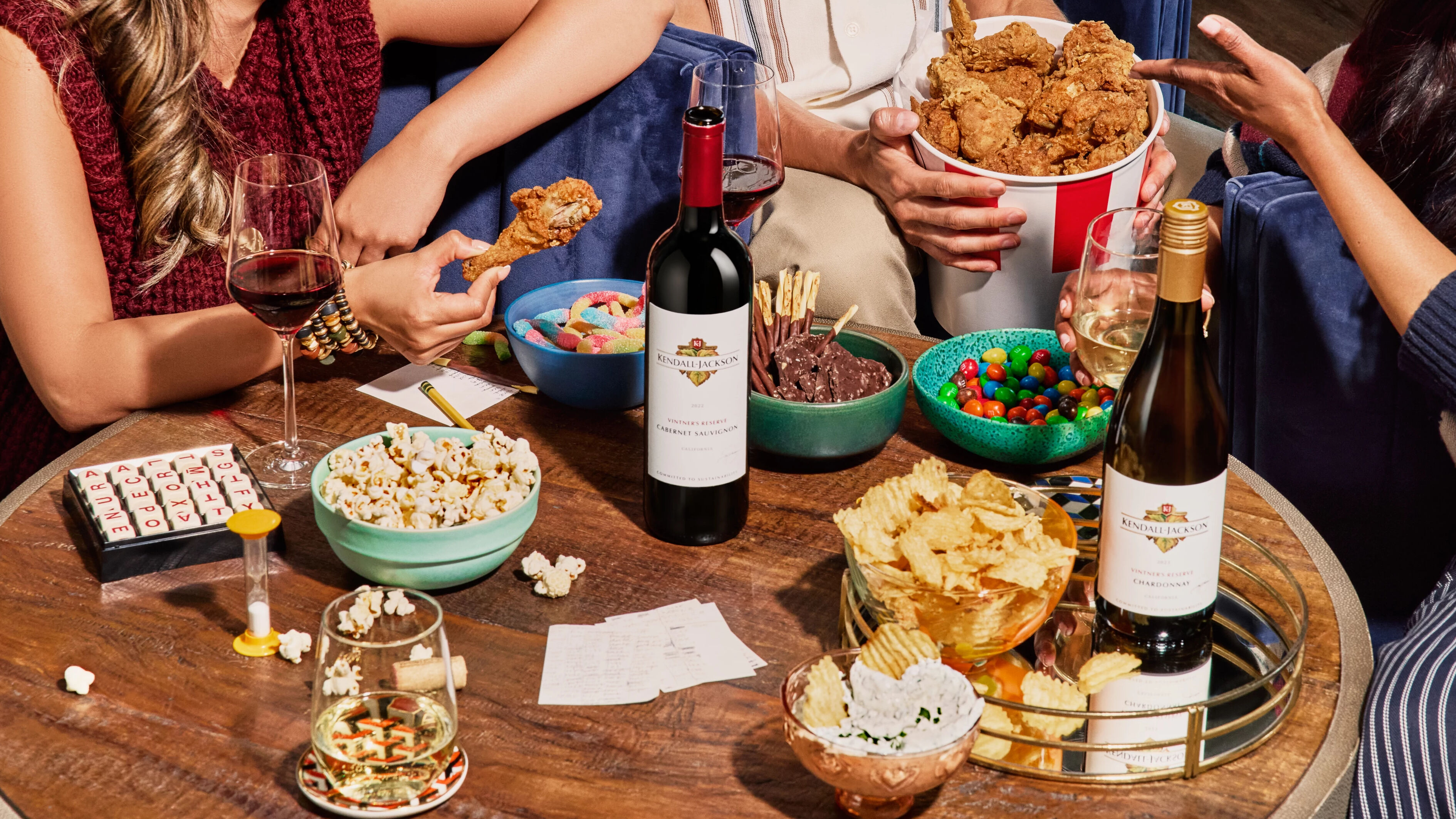 Friends sit around a table with Kendall-Jackson wine and snacks