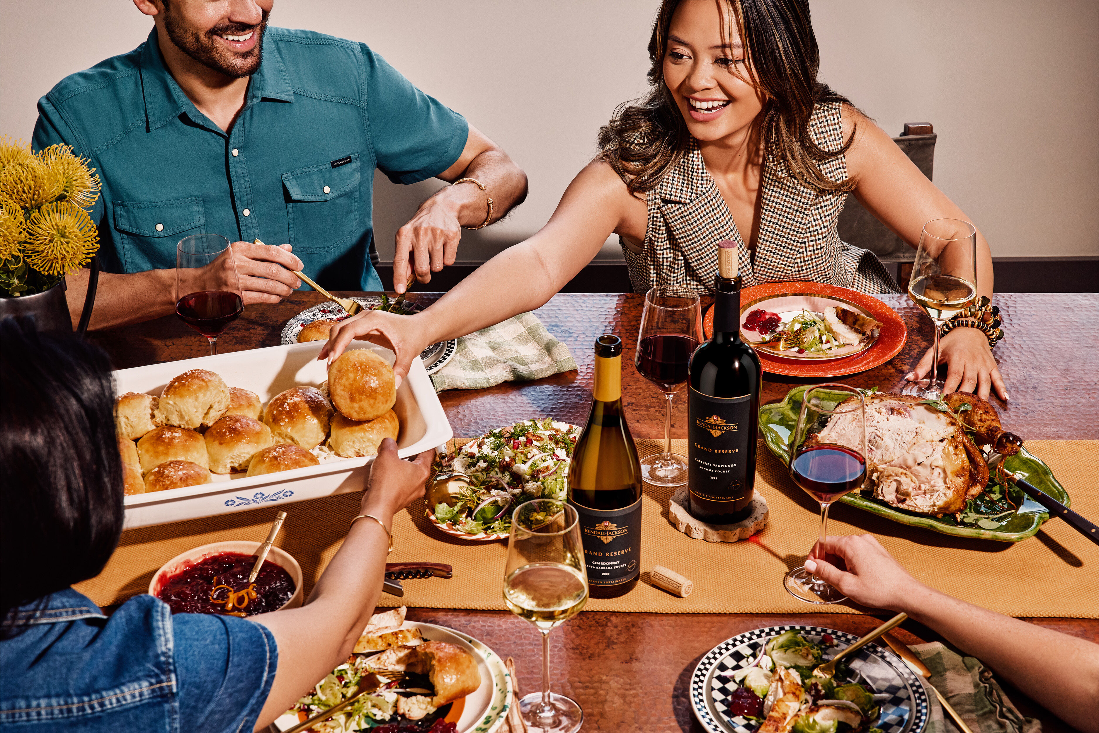 Kendall-Jackson Grand Reserve Wines at a Friendsgiving celebration with four people enjoying them and laughing because they are having so much fun and love drinking our wine.