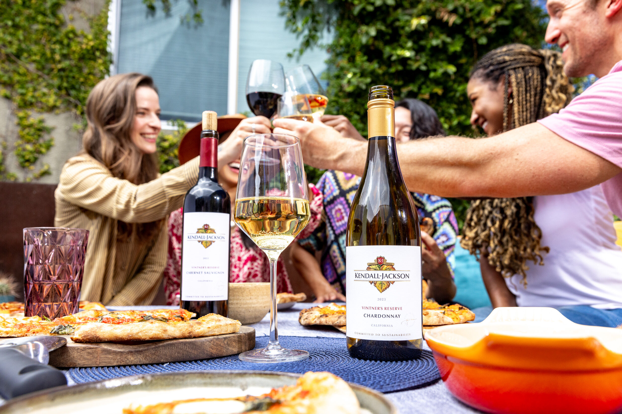 A group cheersing with bottles of Kendall-Jackson wines