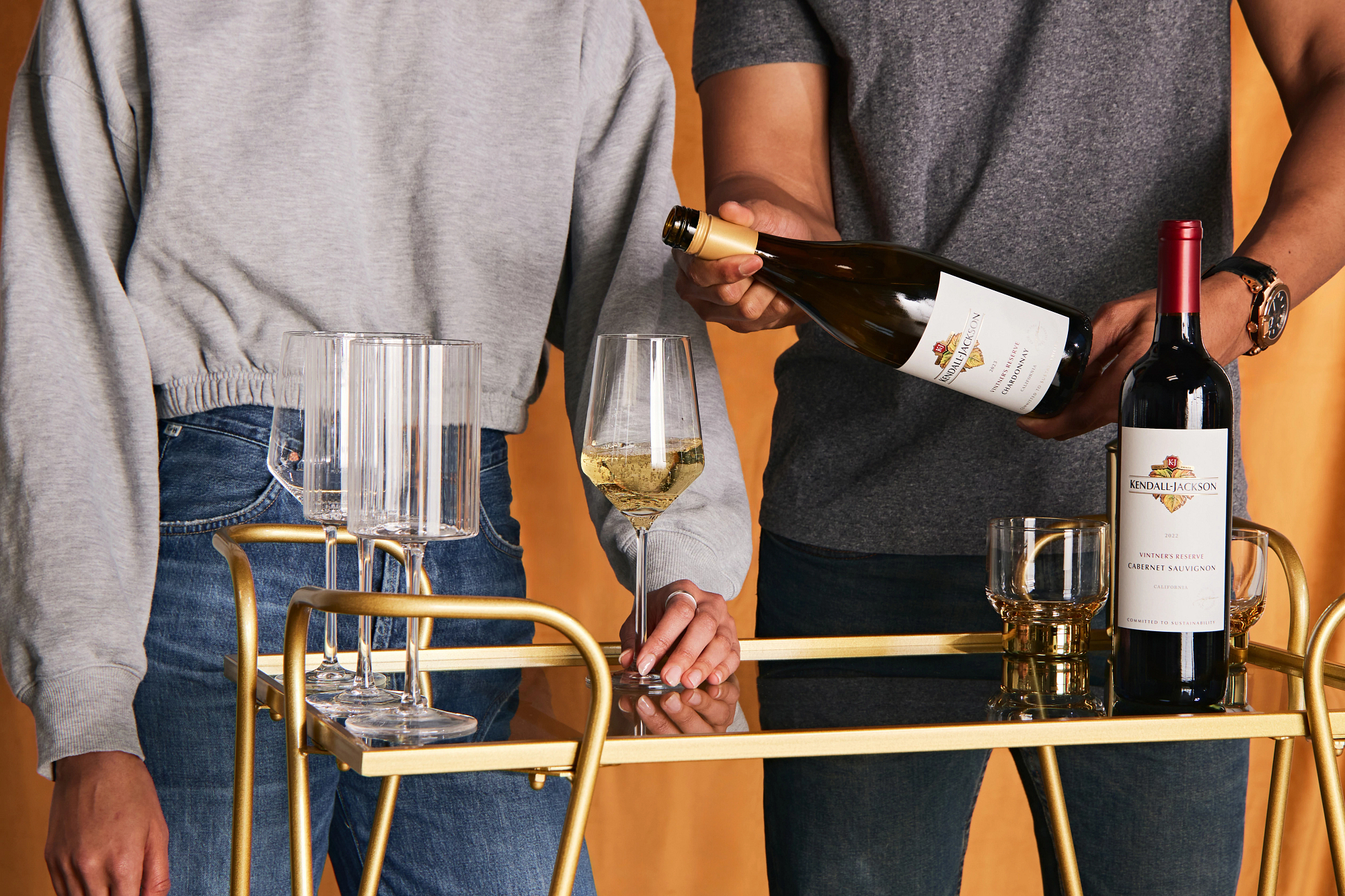 Two friends pouring Kendall-Jackson wines on a bar cart