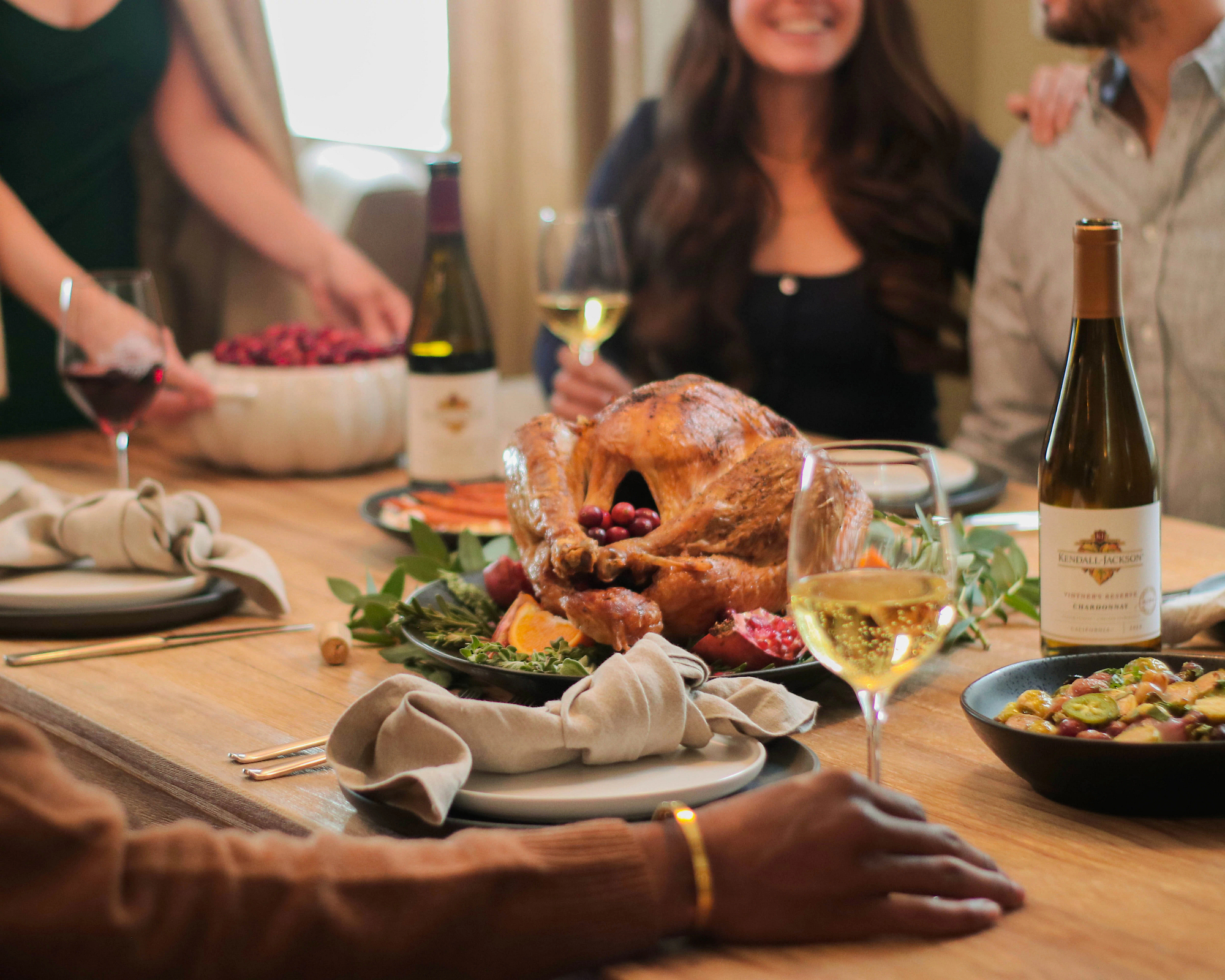 A group of people enjoying a Thanksgiving turkey dinner with Kendall-Jackson Chardonnay