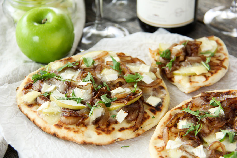 This Caramelized Onion, Apple and Brie Flatbread recipe is an ideal summer appetizer for an outdoor bbq or to enjoy as a personal entree for yourself.