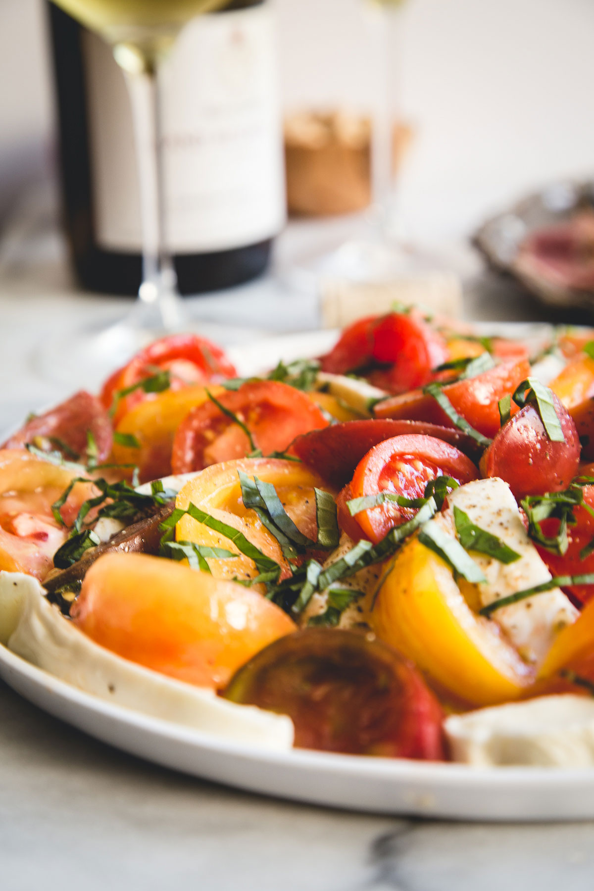 To highlight the heirloom tomato and let it speak for itself, we want to share this stunning heirloom tomato & mozzarella salad recipe with you! This bright summer salad is perfect for outdoor barbecues, a date night in or with a nice side of grilled beef.